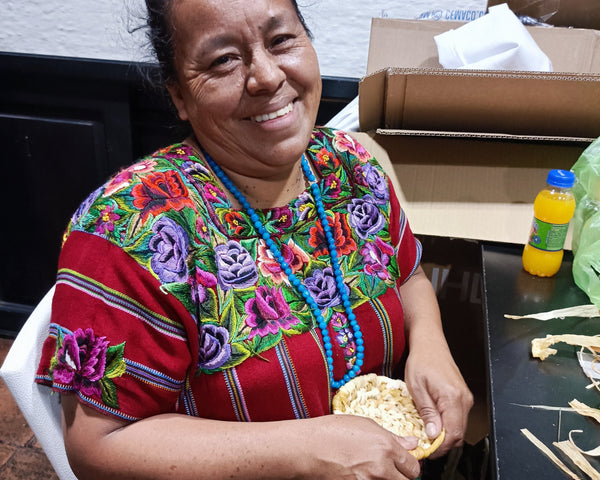 A Guatemalan woman makes a straw basket.